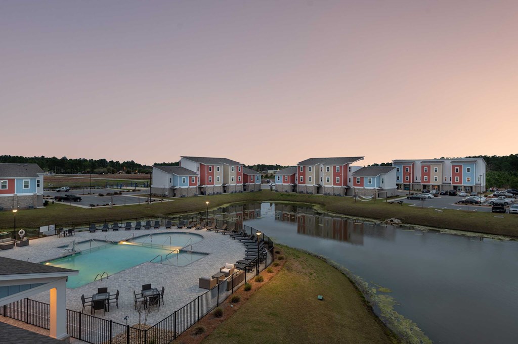 a building with a pool and a lake at dusk