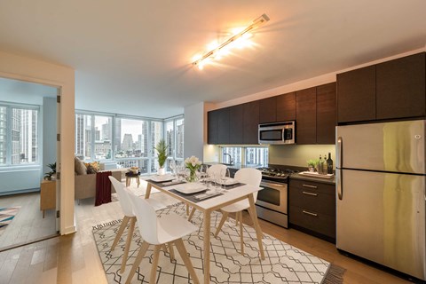 A modern kitchen with a dining table and chairs in the foreground.