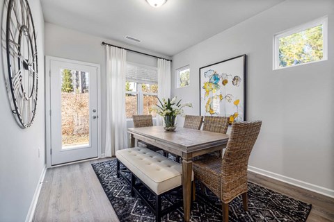 a dining room with a table and chairs and a door at Ashford Townes Apartments, North Carolina