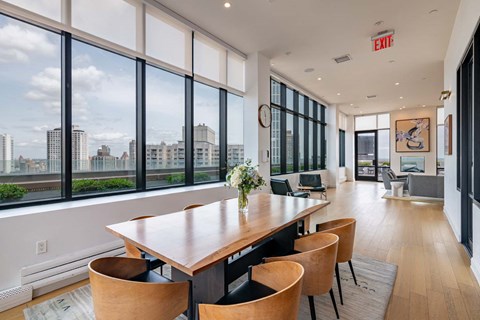 a dining room with large windows and a table with chairs