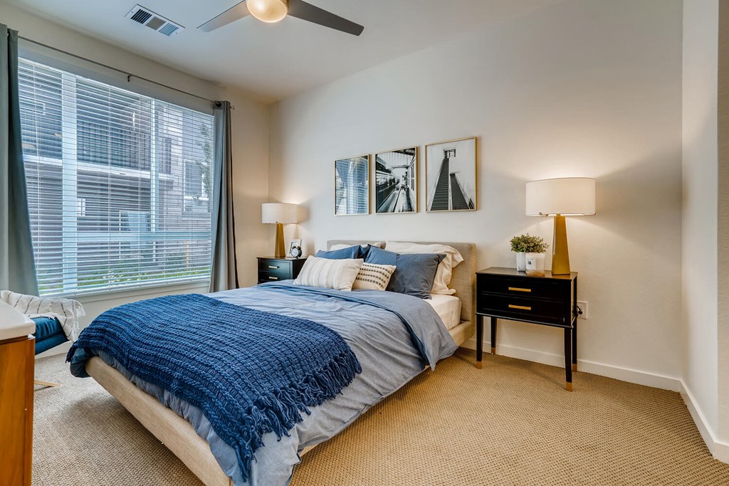 a bedroom with a large window and a bed