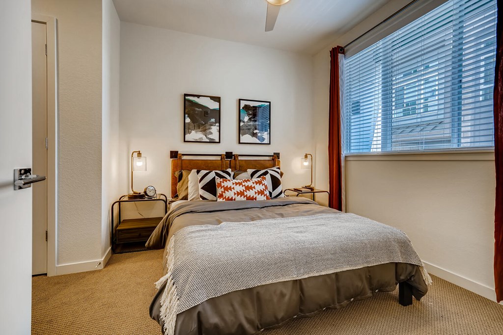 a bedroom with a bed and a large window