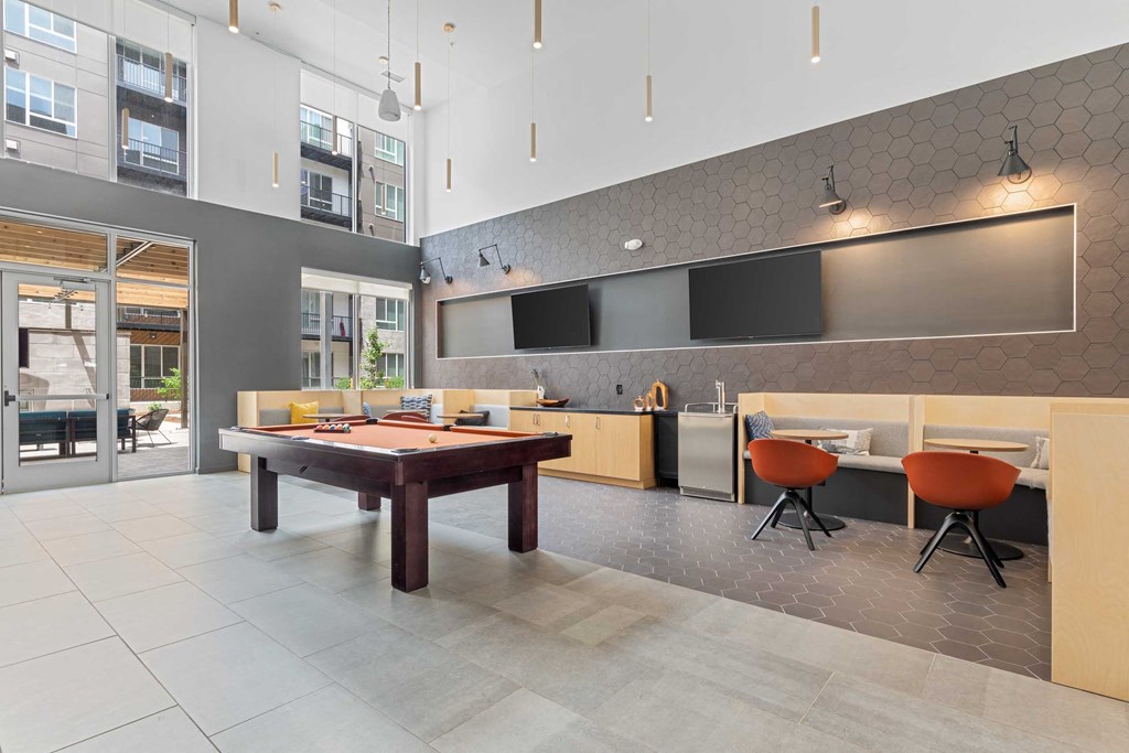 a game room with a pool table  and a kitchen