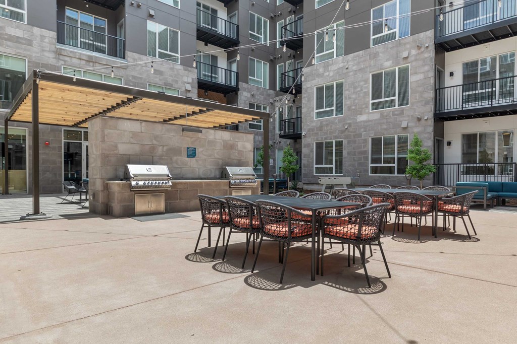 an outdoor patio with tables and chairs at an apartment building