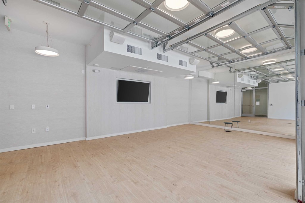 a large room with a wooden floor and a tv on the wall