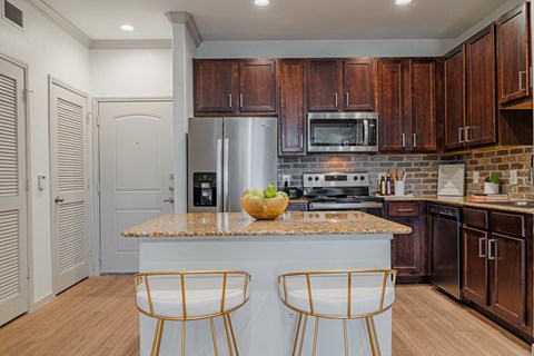 Kitchen area with wooden cabinetsat Auxo at Memorial, Houston, TX