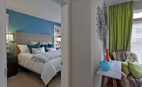 a bedroom with a bed and green curtains