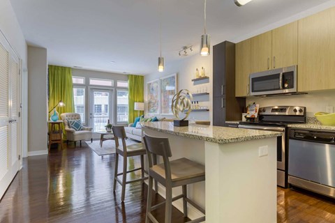 A kitchen with a white counter and a microwave on top.