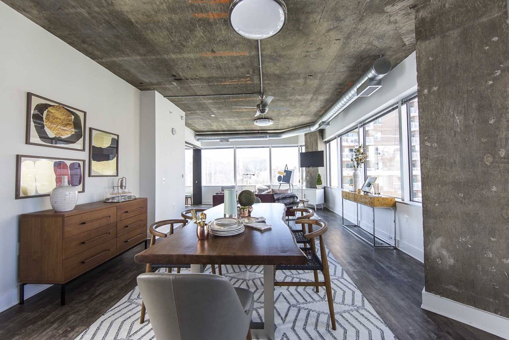 a dining room and living room with a wooden table and chairs