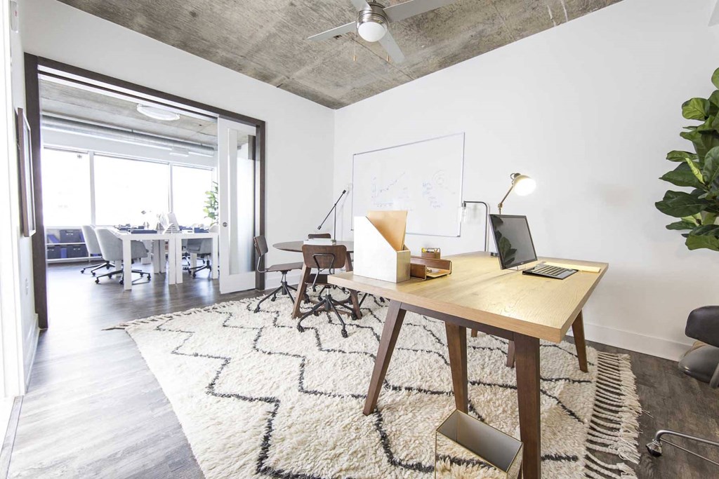 a home office with a desk and a whiteboard and a rug