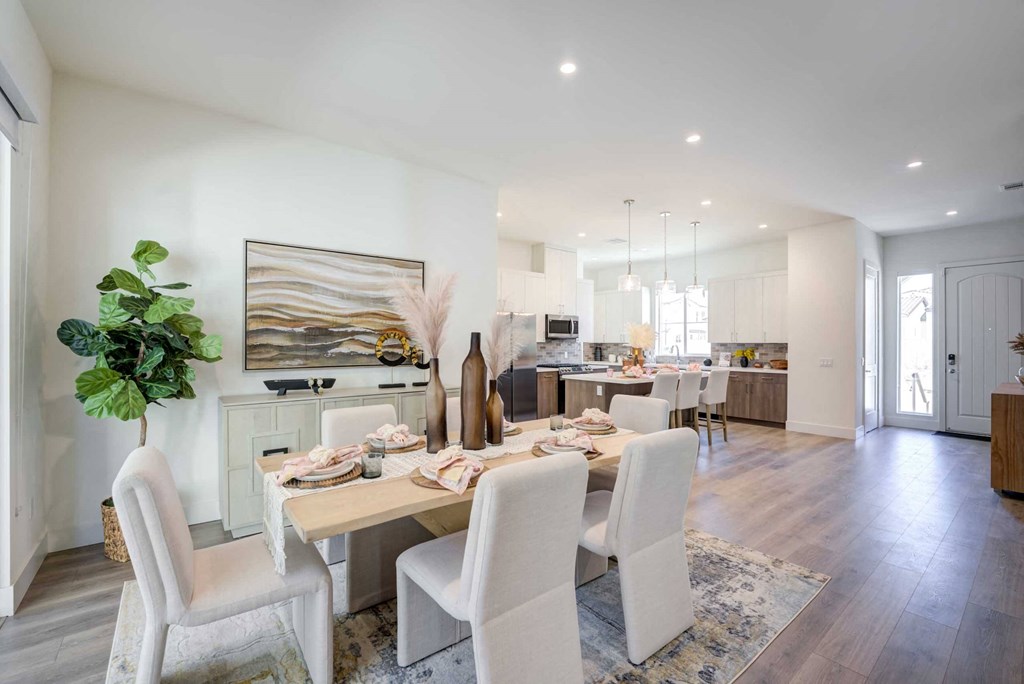 a dining room table with chairs in front of a kitchen