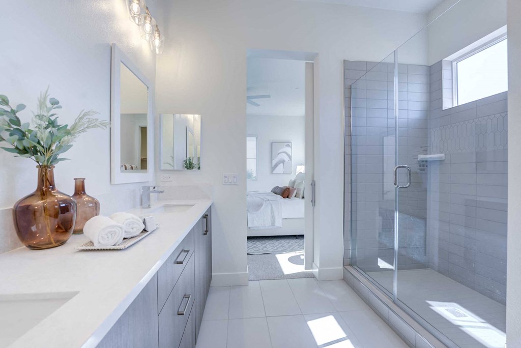 a white bathroom with a shower and two sinks