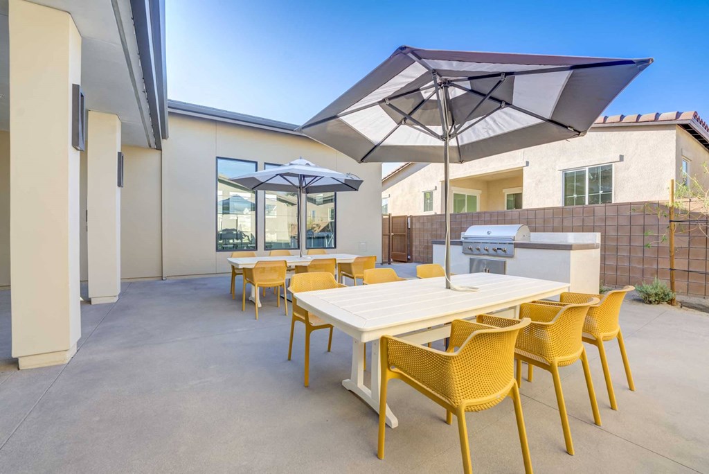 a patio with a table and chairs and umbrellas