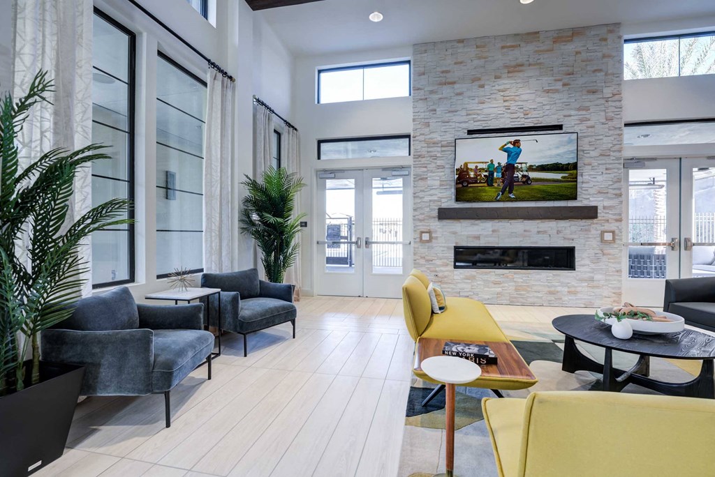 a living room with yellow chairs and a television