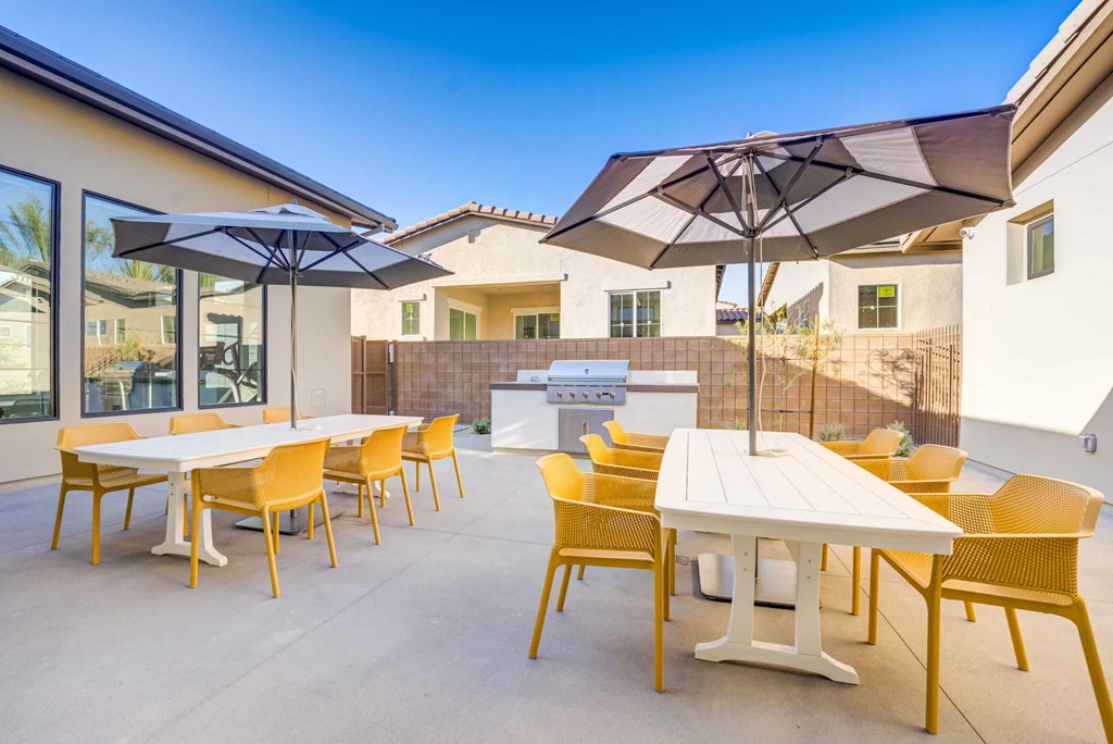 a patio with tables and chairs and umbrellas