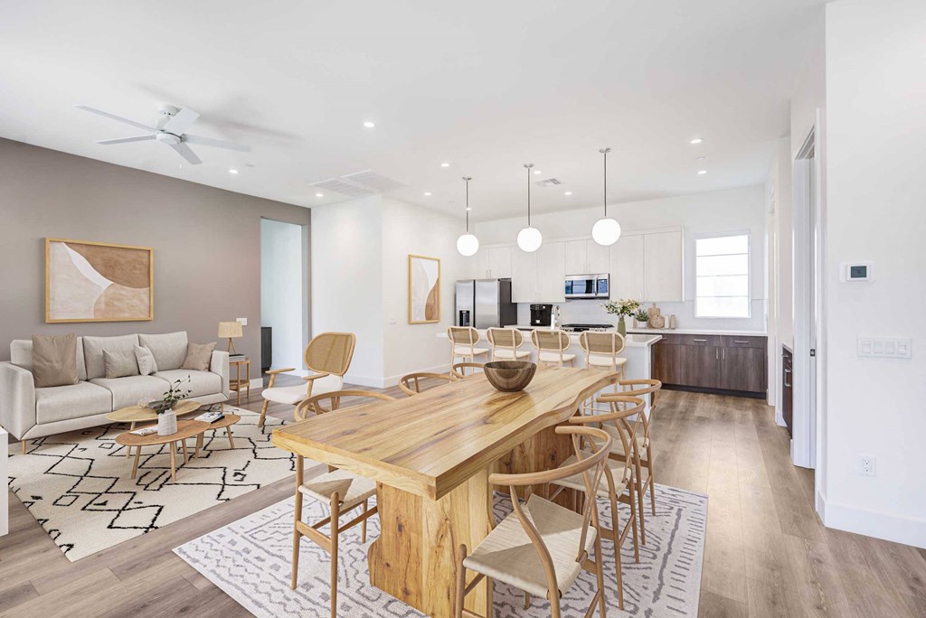 a living room and dining room with a wooden table