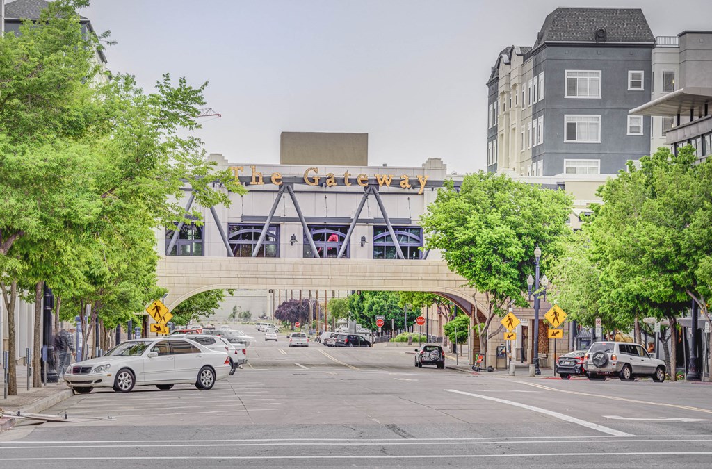a bridge over a city street with cars and a train on it