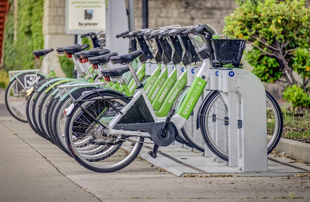 a row of bikes parked in a bike rack