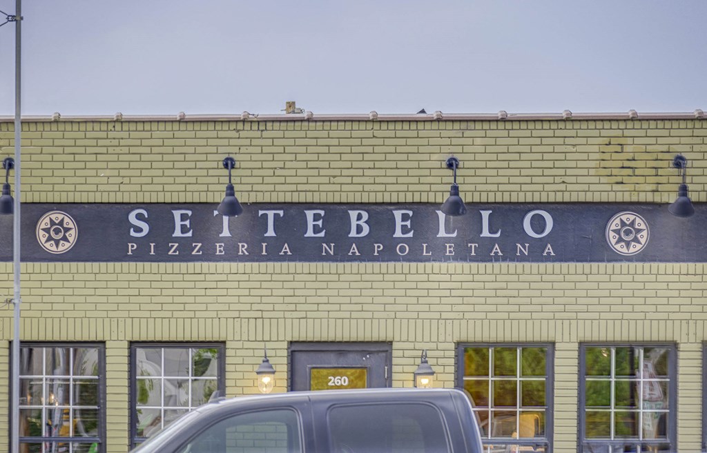 the facade of a building with a sign that reads settebello pizzeria
