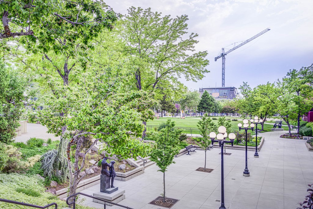 a park with trees and statues and a field in the background