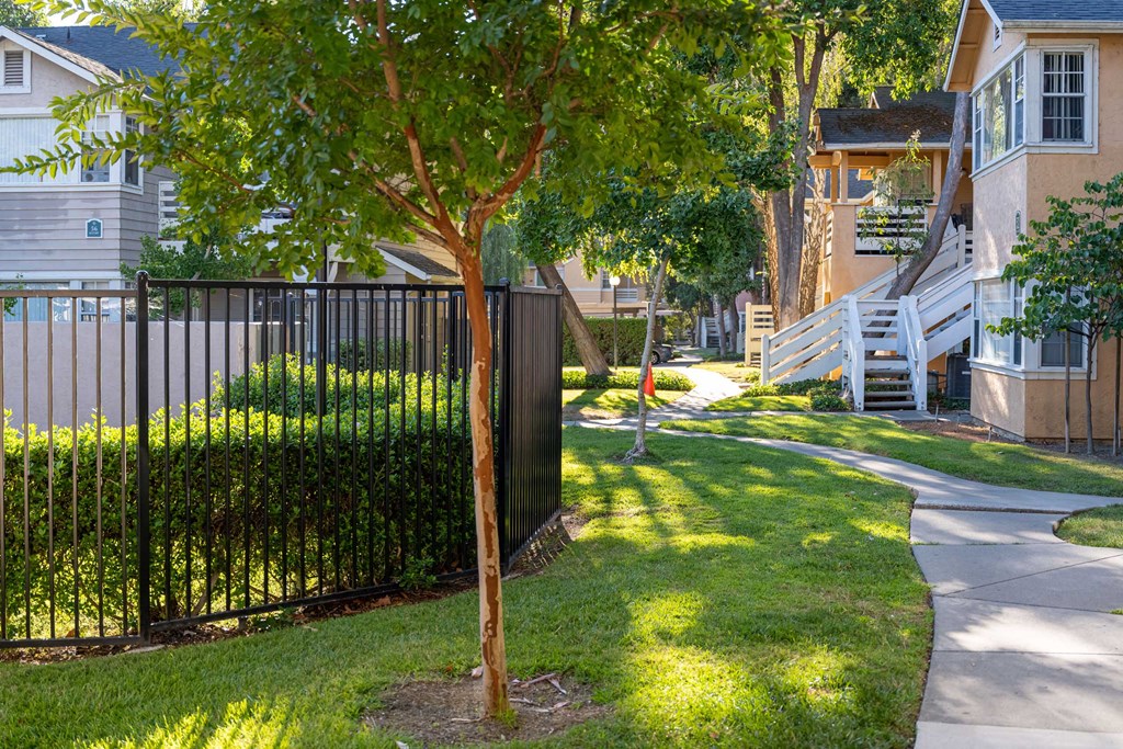a sidewalk in front of a row of houses