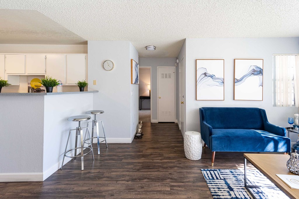 a living room with a couch and a kitchen with a bar