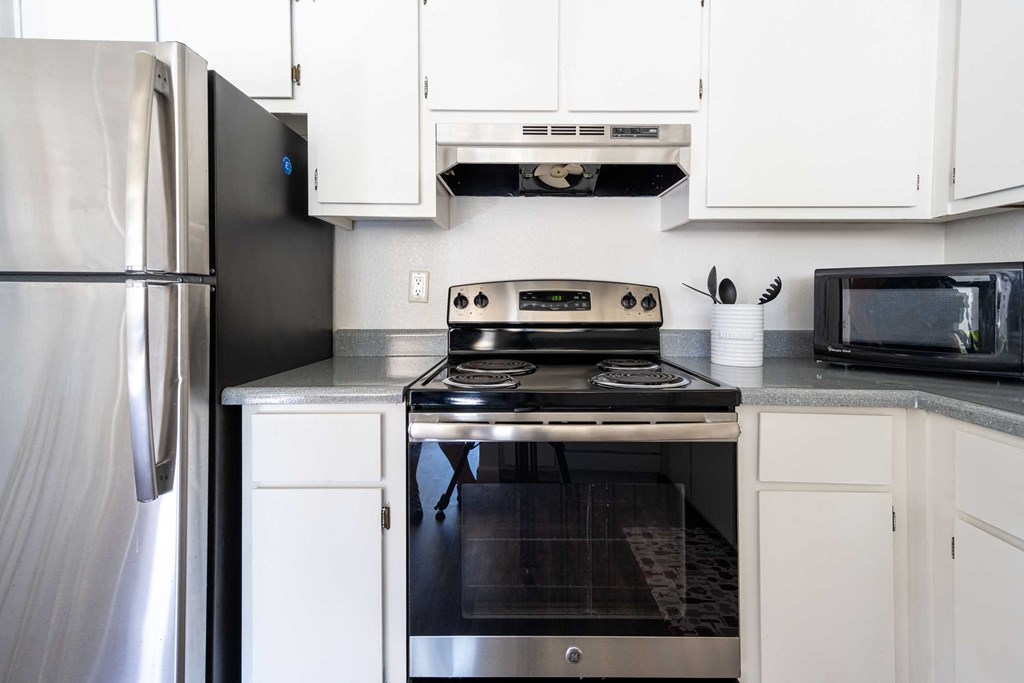 a kitchen with stainless steel appliances and white cabinets