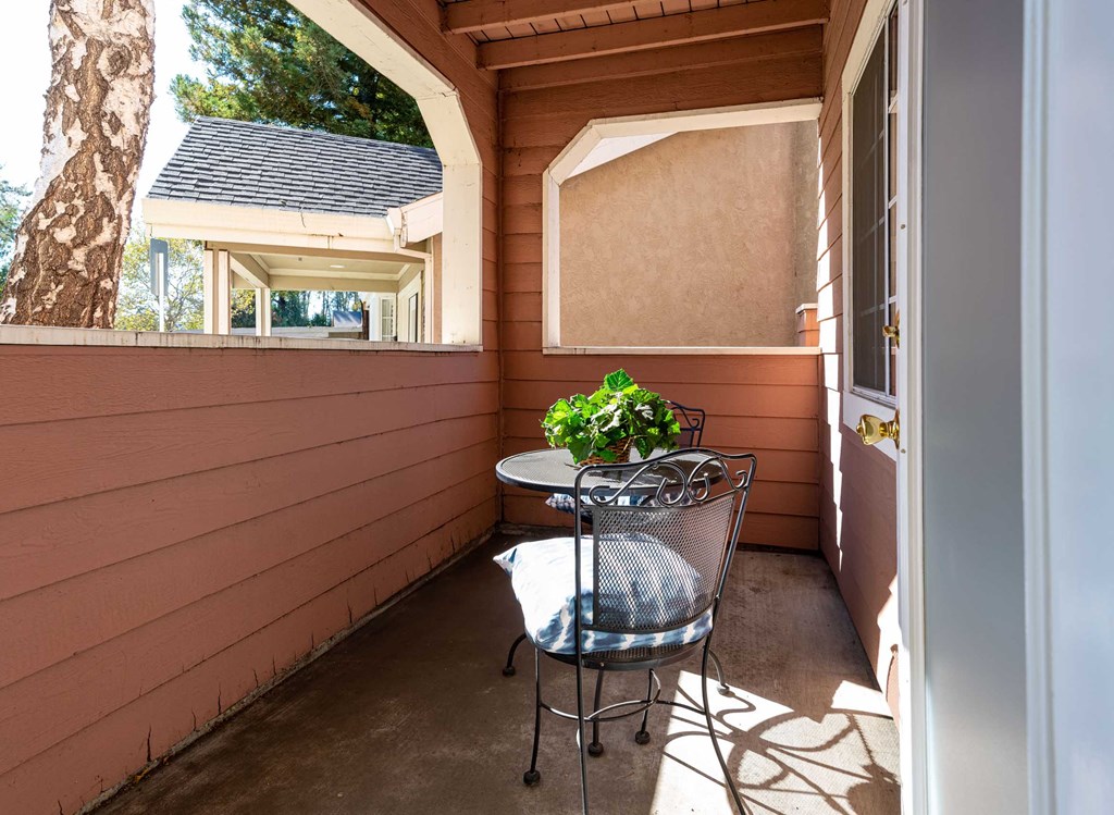 a patio with a table and a chair on a porch