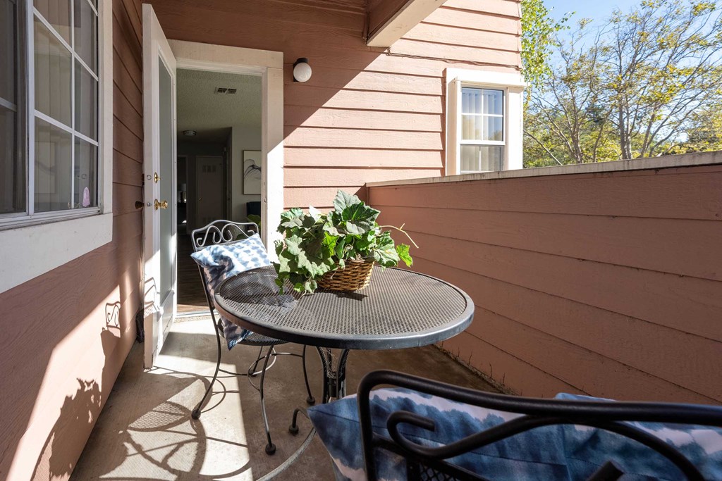 a front porch with a table and chairs and a potted plant