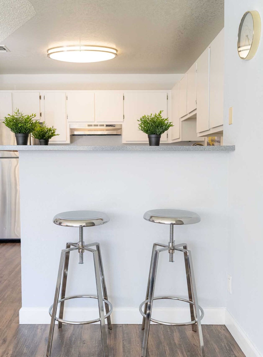a kitchen with three bar stools in front of a counter