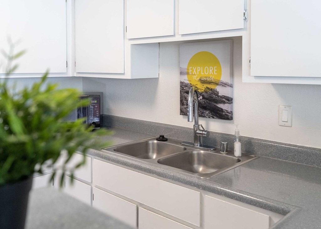 a kitchen with a sink and a sign on the wall above it