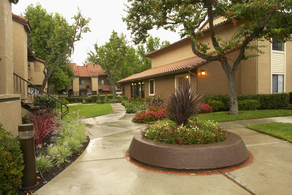 a courtyard with trees and plants in front of a building