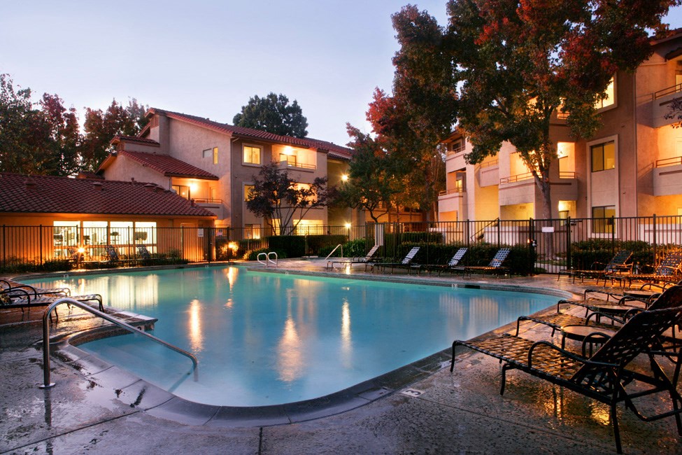 the swimming pool at night at an apartment complex