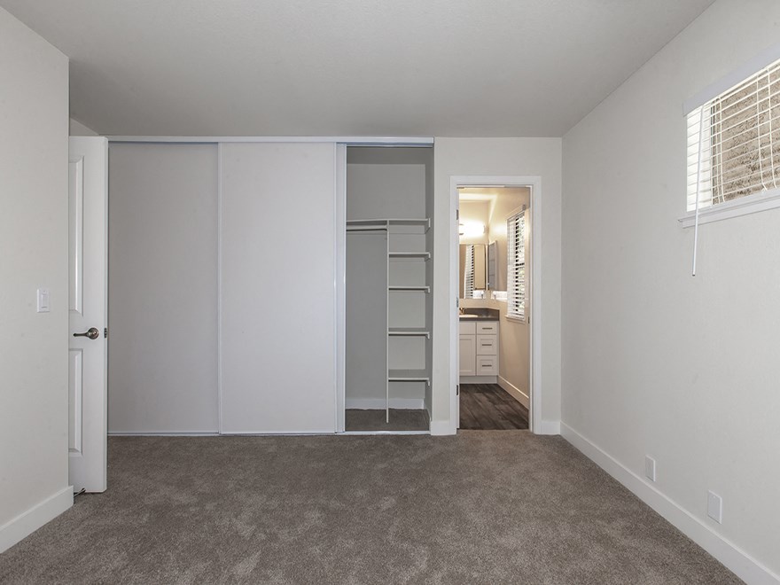 an empty bedroom with a closet and a bathroom
