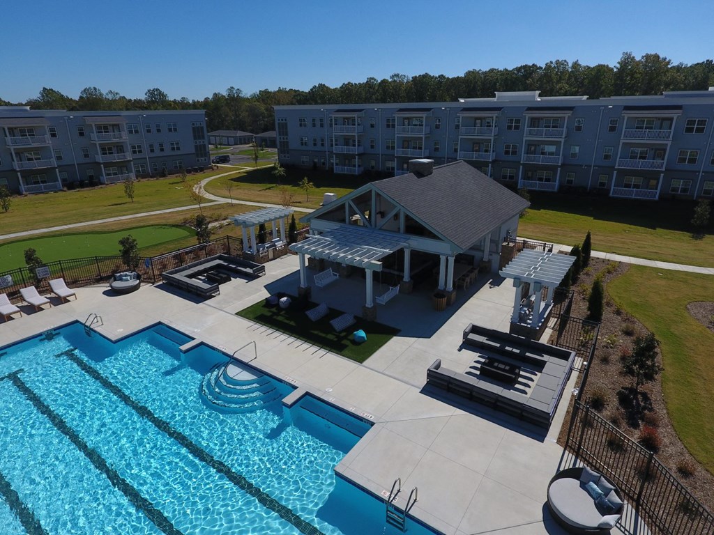 an aerial view of a swimming pool with a clubhouse and a resort style poolside