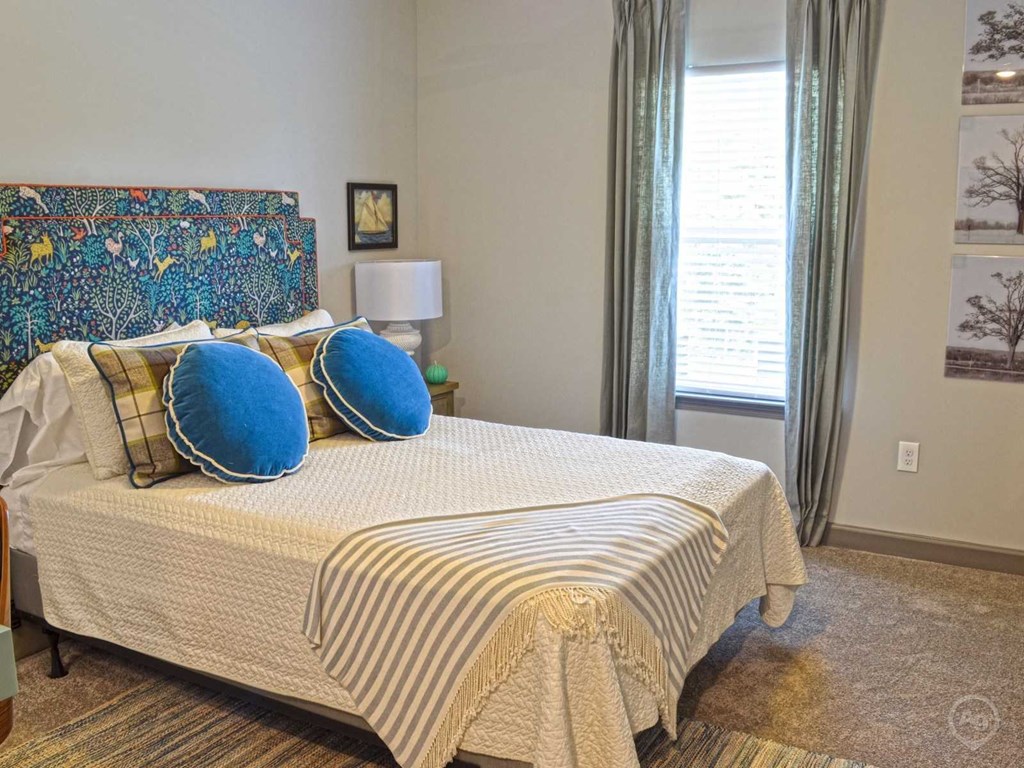 a bedroom with a bed with blue pillows on it