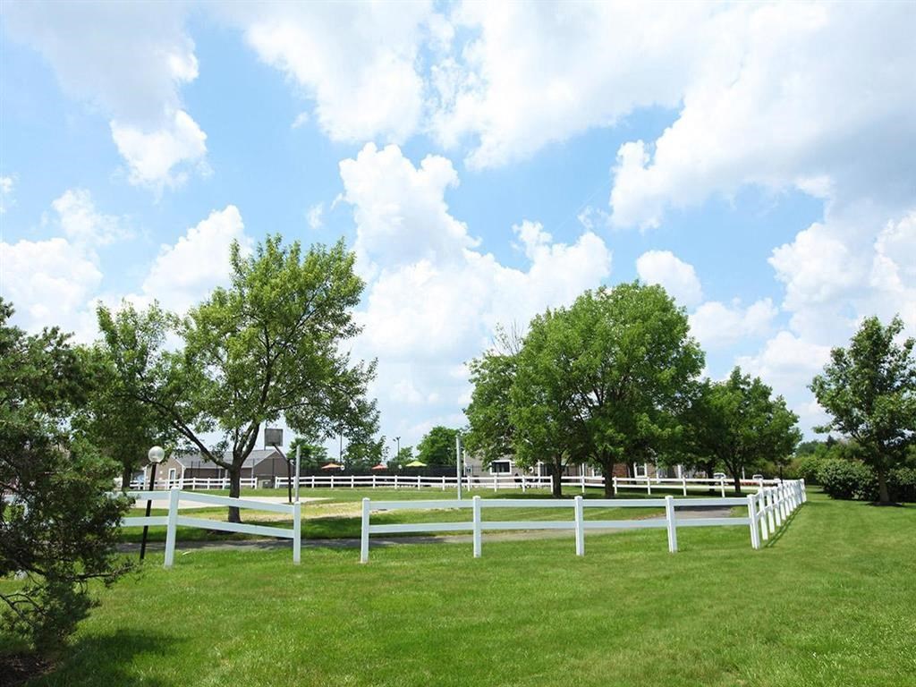a white fence in the middle of a grass field
