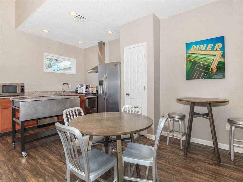 a dining area with a table and chairs and a kitchen with a sink