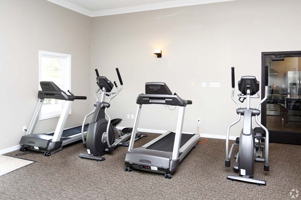a gym with treadmills and other exercise equipment in a room