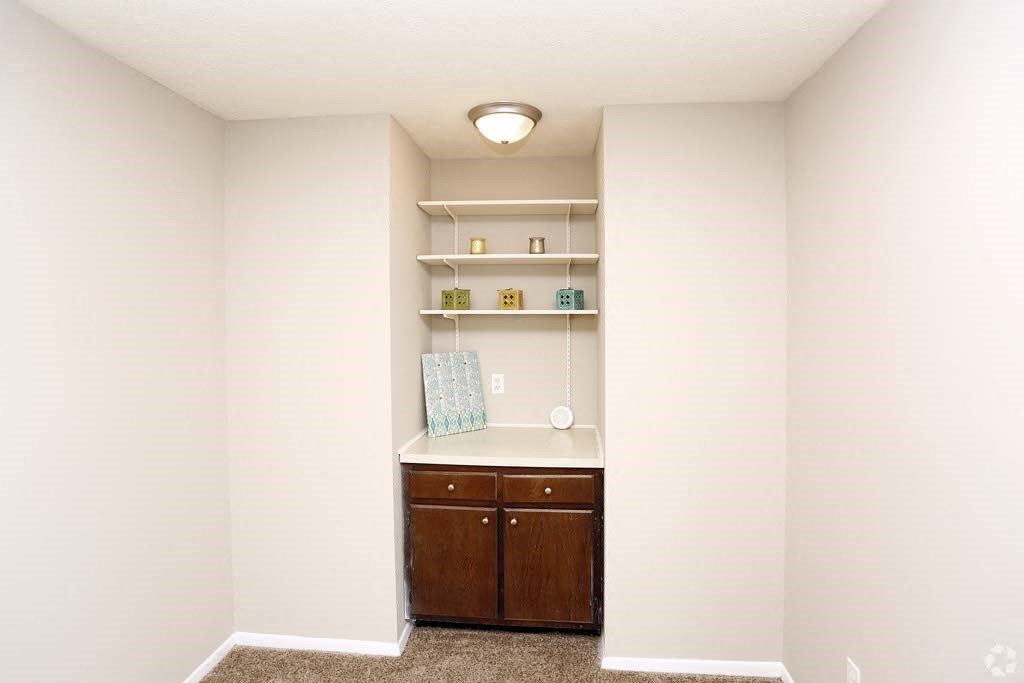 an empty room with a counter and shelves in it
