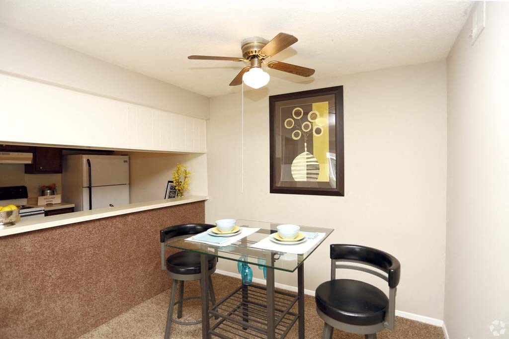 a dining room with a table and chairs and a ceiling fan