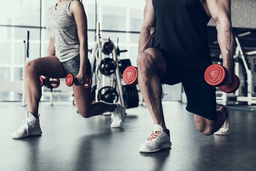 two people working out in a gym with weights