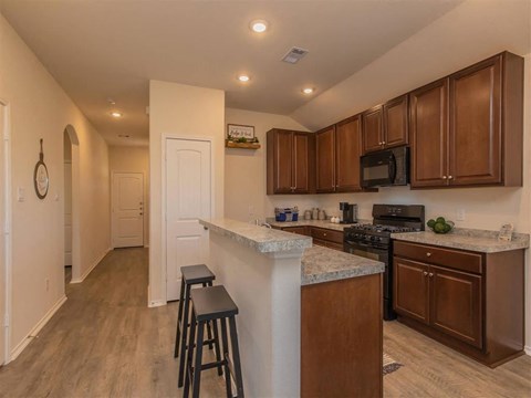 A kitchen with brown cabinets and a white island.