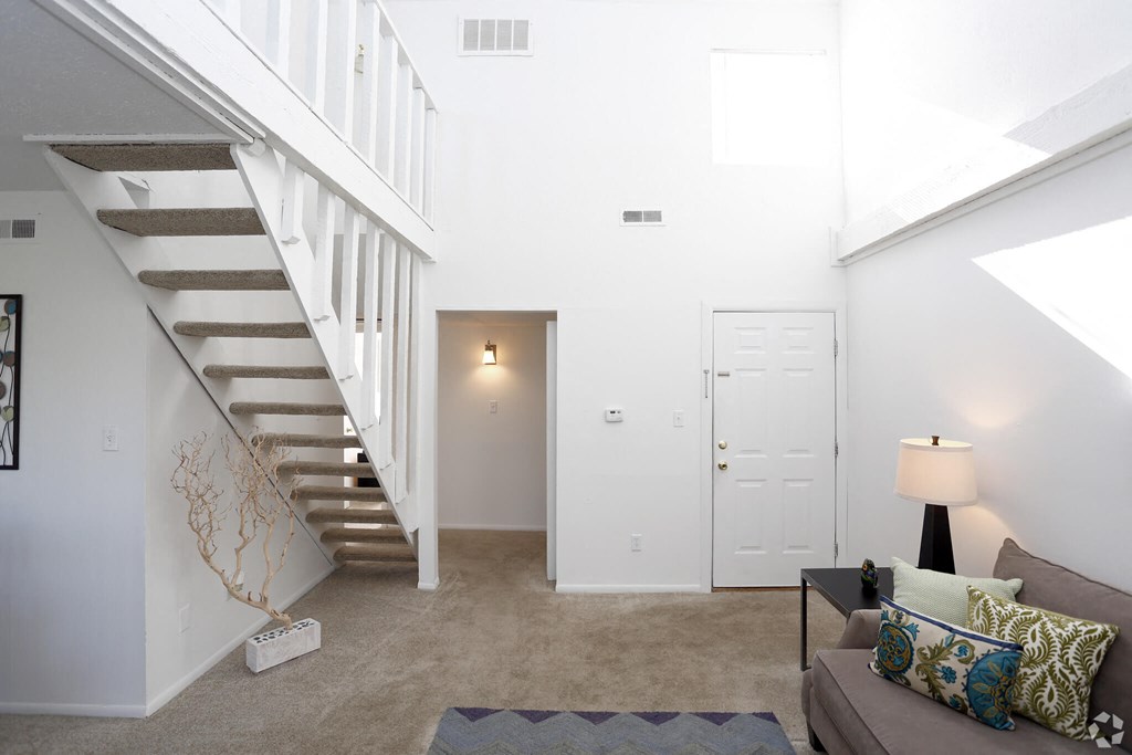 a living room with a staircase and a couch