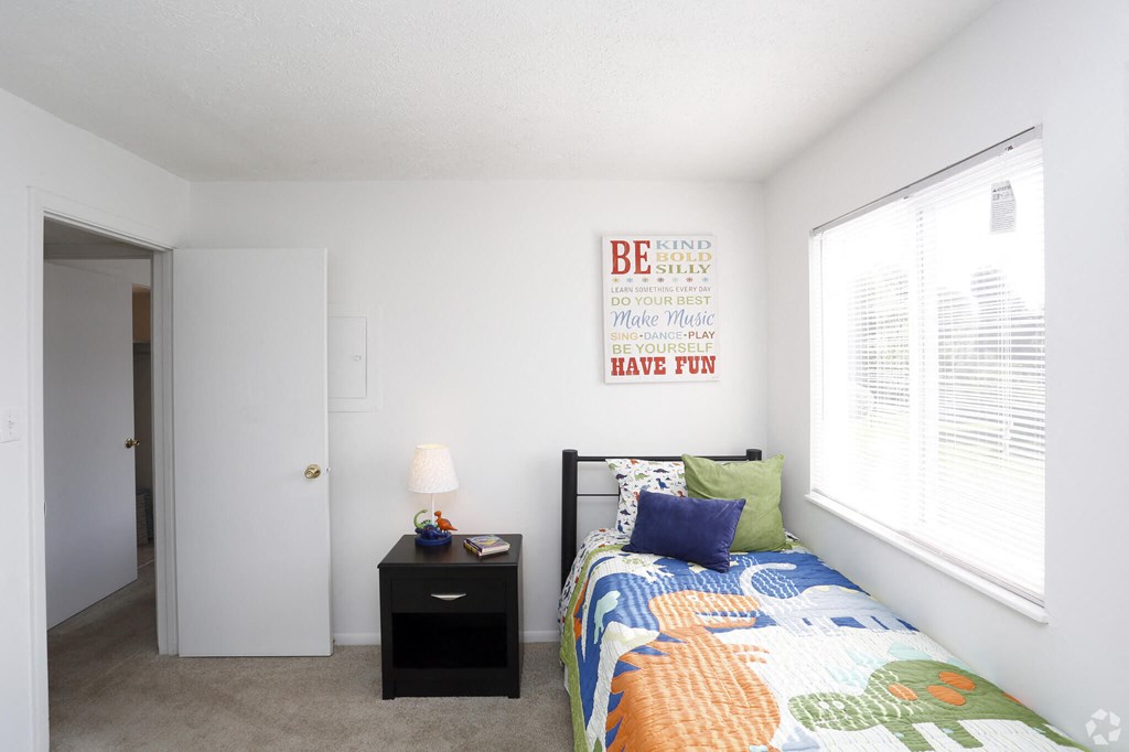 a bedroom with a bed and a large window