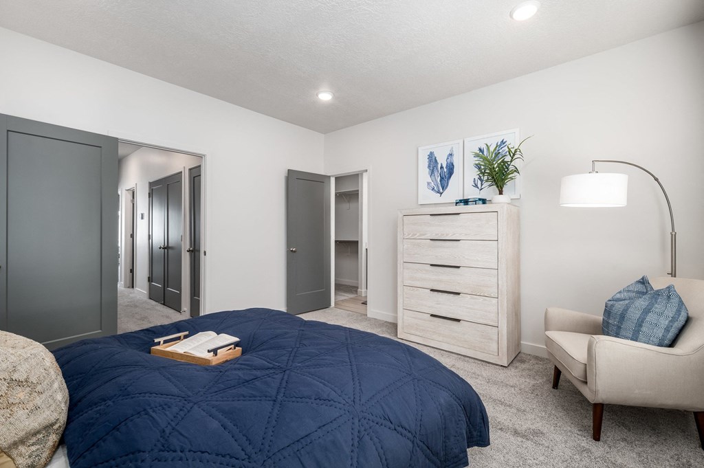 a bedroom with a bed and a chair and a closet