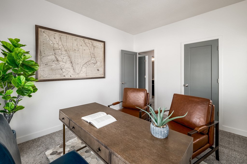 a conference room with two leather chairs and a wooden desk