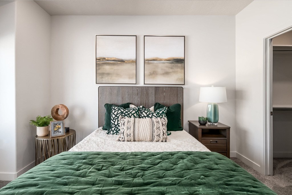 a bedroom with a large bed and two pictures on the wall