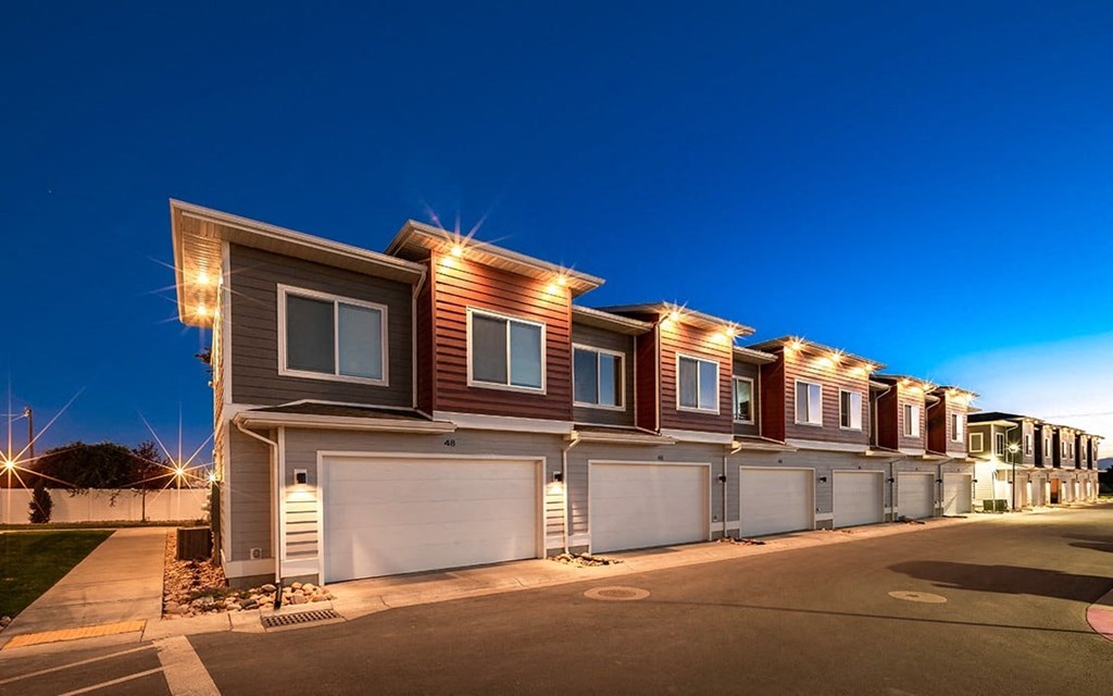 a row of houses with garages at night