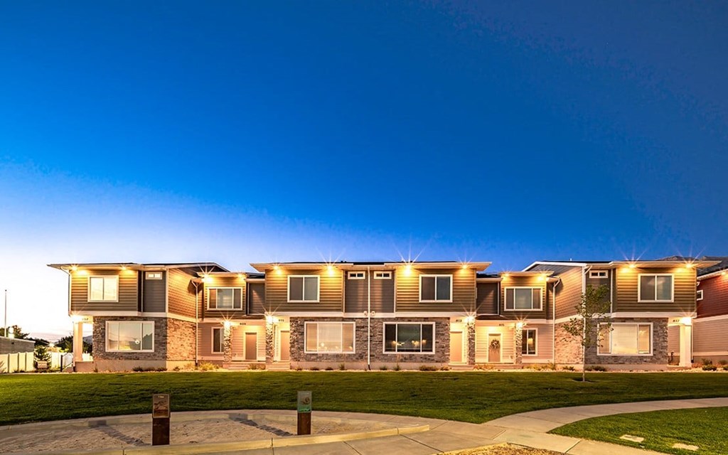 a row of apartments with lights on at dusk